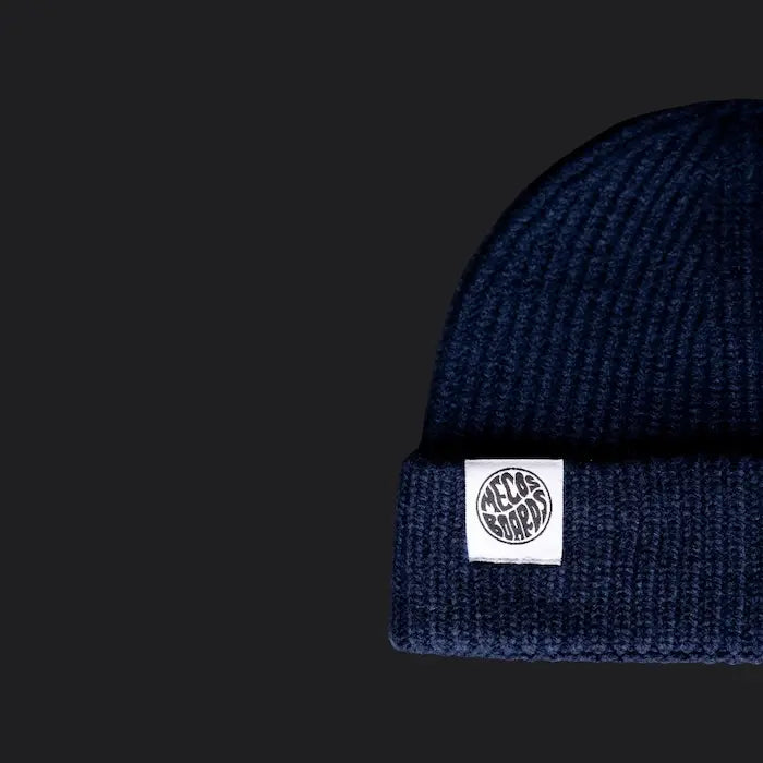 Dunkelblaue Strickmütze von MECOS BOARDS mit Logo-Patch – bequem, stylisch und ideal für schmalere Köpfe.