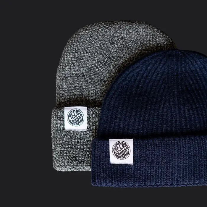 Wintermützen von MECOS BOARDS in Grau und Navy – klassischer Schnitt mit Logo für Wärme und Style.