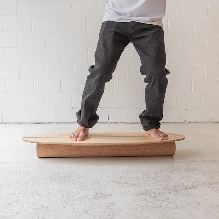 Surf Trainer Balance Board aus Holz auf Korkrolle – Seitenansicht in Bewegung