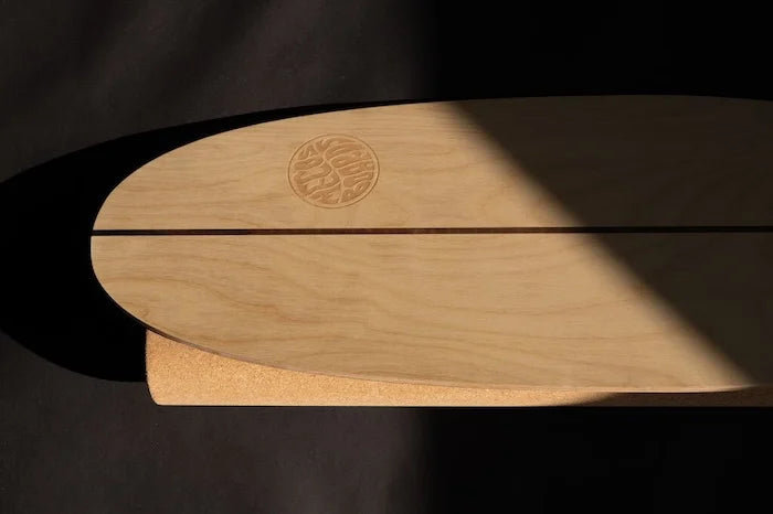 Oberfläche des Surf Trainer Balance Boards mit Logo im stimmungsvollen Schattenlicht – hochwertiges Holzdesign für realistisches Surftraining