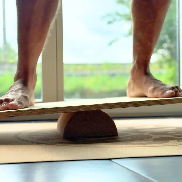 Detailaufnahme: Füsse auf THE SHORTY Balance Board mit halber Korkrolle von Mecos Boards – ideales Training für Einsteiger:innen.