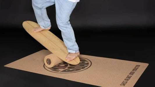 THE TWIN-TIPPER Balance Board beim Balancieren auf einer Korkrolle