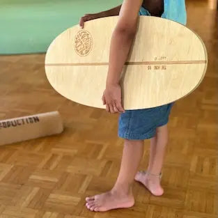 Kind hält das Mini Balance Board von MECOS BOARDS in der Kita