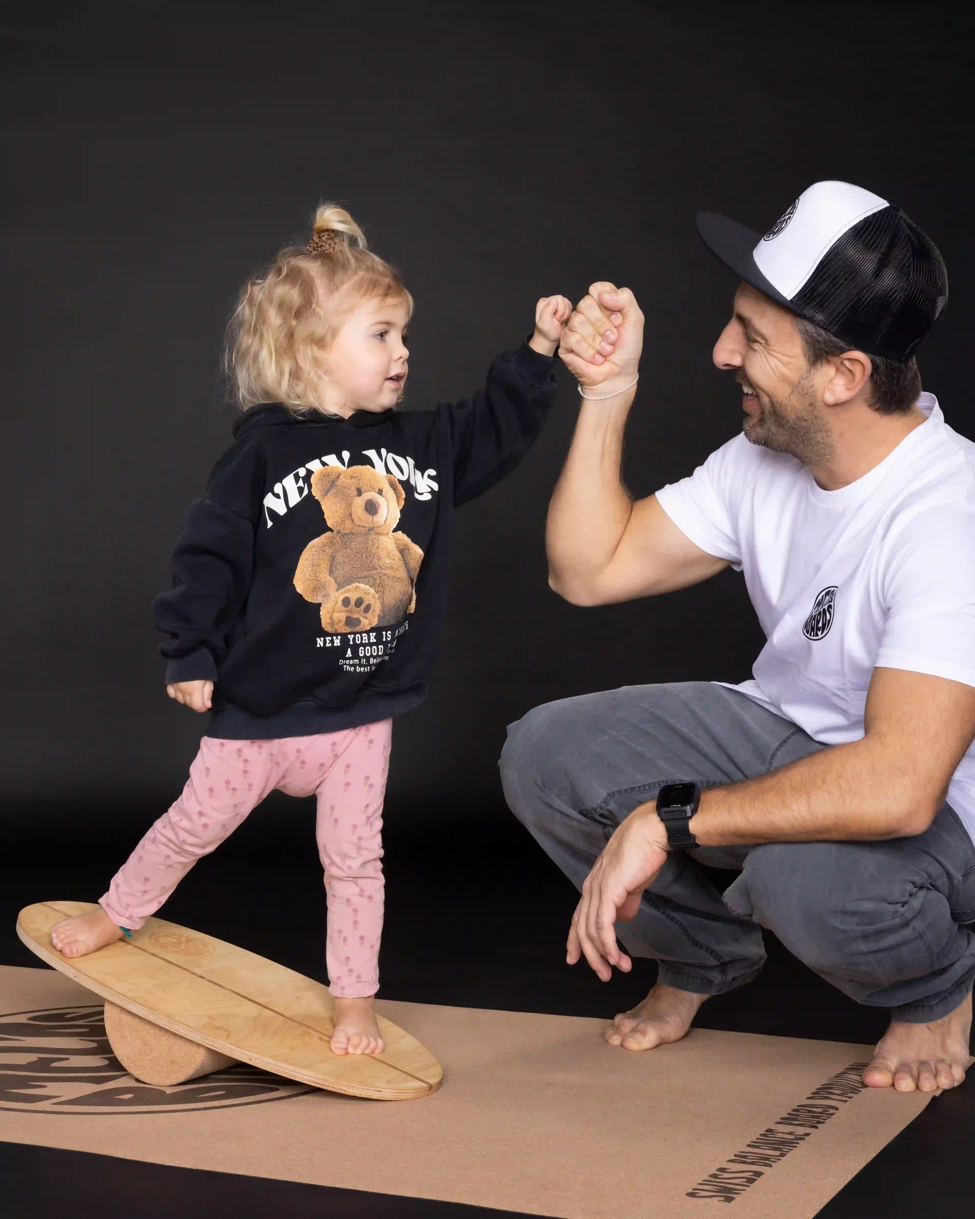 Vater und Kind üben gemeinsam auf dem MECOS BOARDS Mini Kids Balance Board
