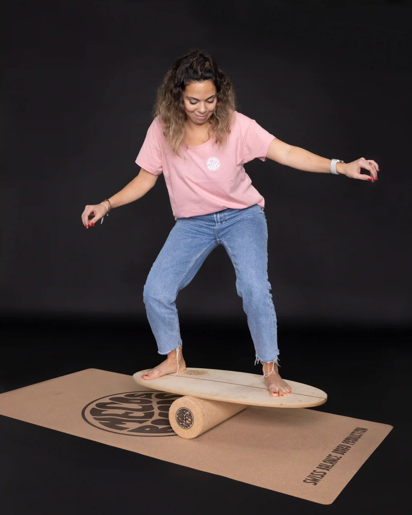 Frau balanciert auf MECOS BOARDS Shorty Balance Board, schwarzer Hintergrund