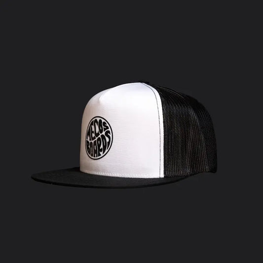 Freigestellte Mecos Boards Trucker Cap in Weiss-Schwarz mit Snapback-Verschluss und aufgedrucktem Logo.
