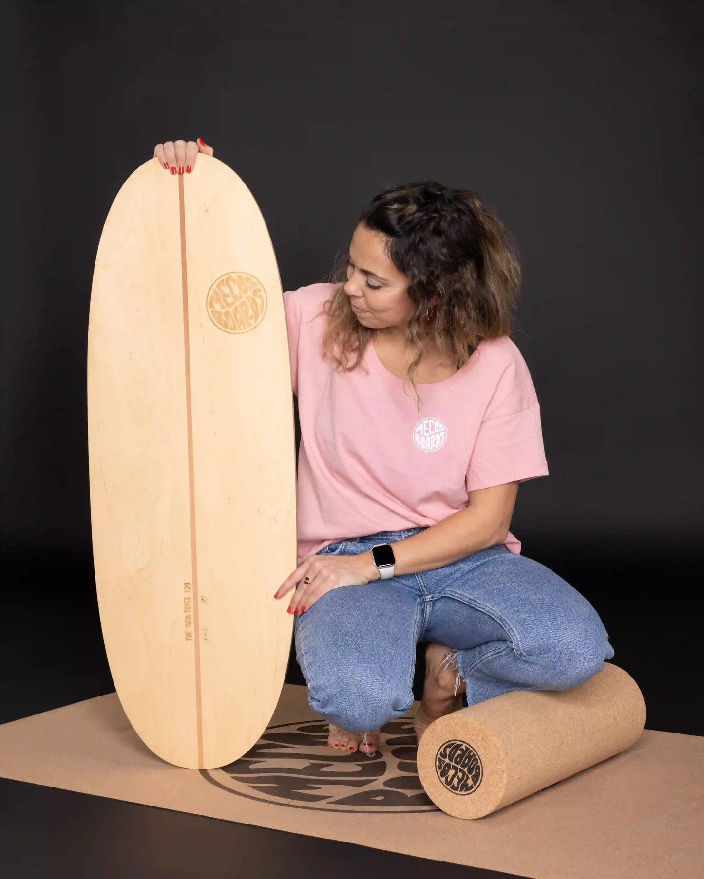 Frau kniet neben MECOS BOARDS Twin-Tipper Balance Board – Einstieg ins Balance Training, alle Levels
