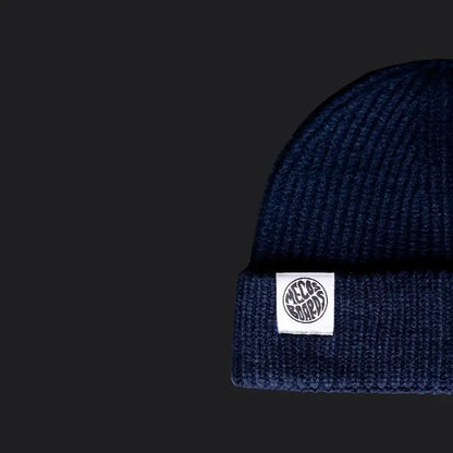 Dunkelblaue Strickmütze von MECOS BOARDS mit Logo-Patch – bequem, stylisch und ideal für schmalere Köpfe.