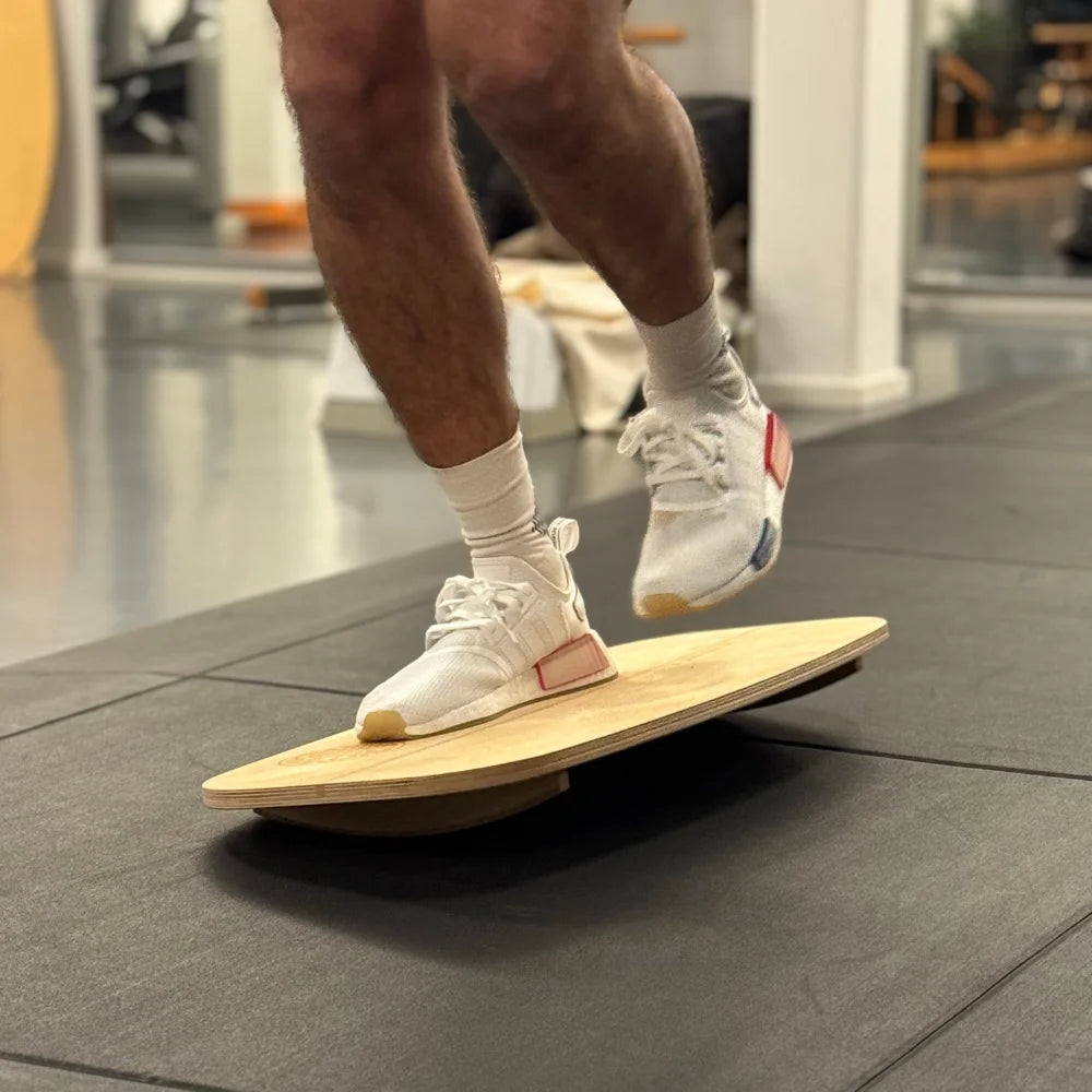 Einbeinige Balanceübung auf dem Motion Rocker zur Verbesserung von Stabilität und Koordination.